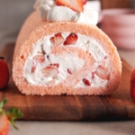 Cross-section view of the end of a strawberry swiss roll to show the filling inside.