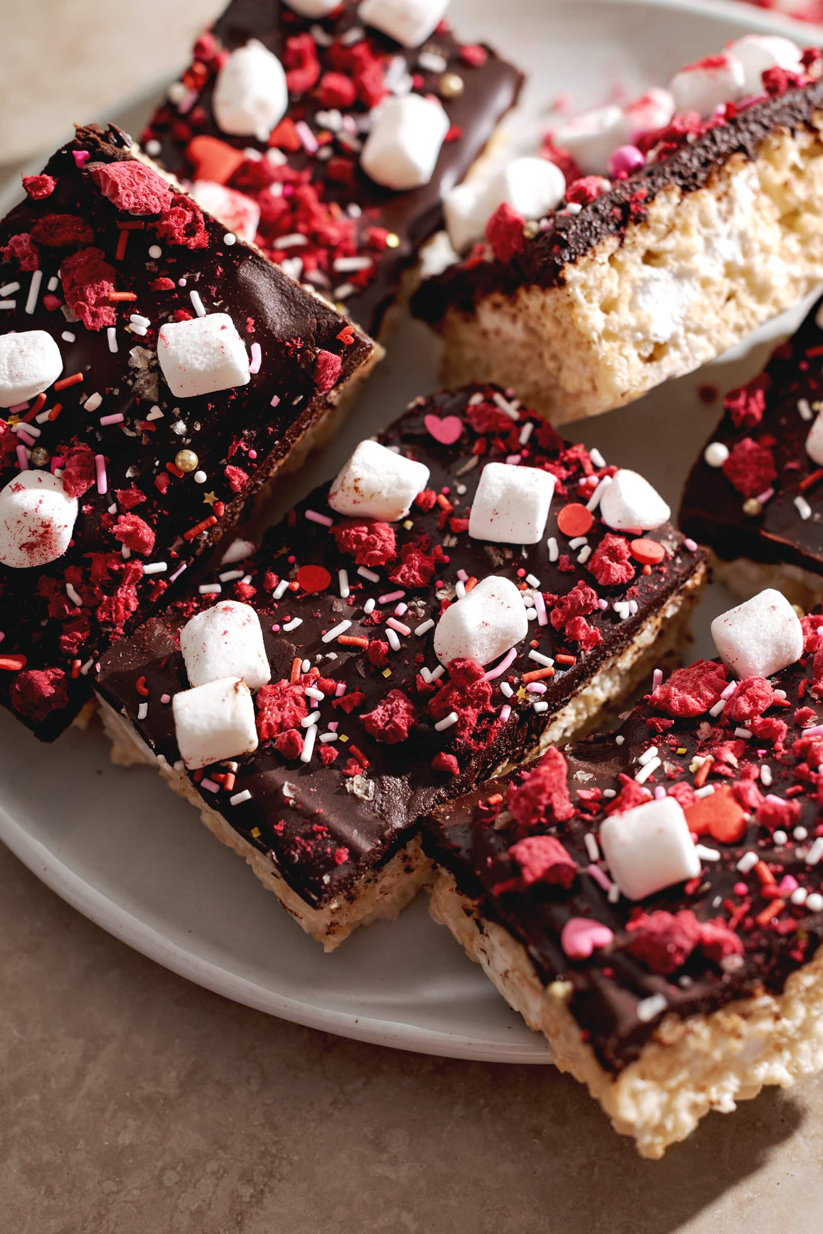 Rice krispie treats covered with chocolate ganache, sprinkles, freeze dried raspberries, and marshmallows.