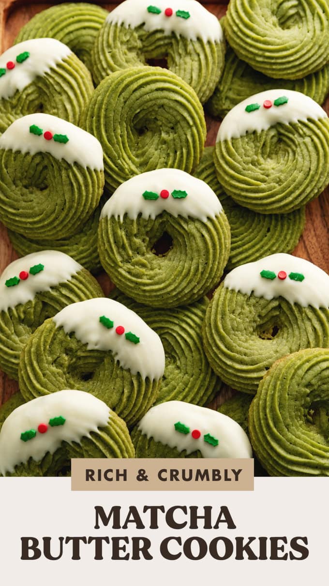 Several matcha butter cookies scattered and overlapping on a wooden tray.