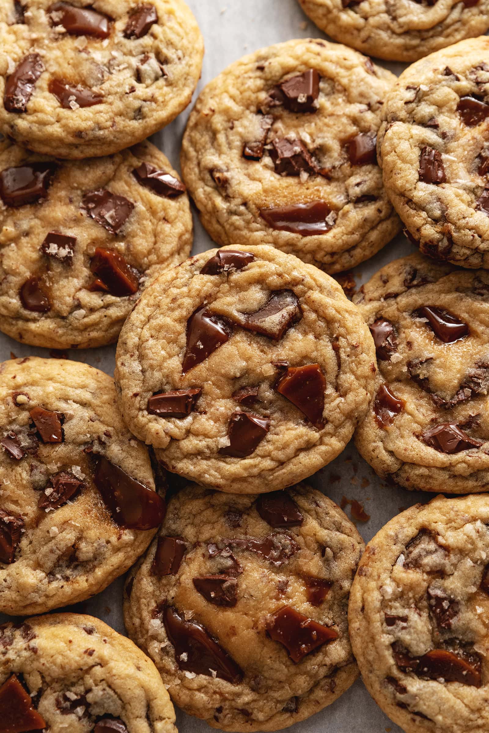 Several toffee cookies slightly overlapping on parchment paper.