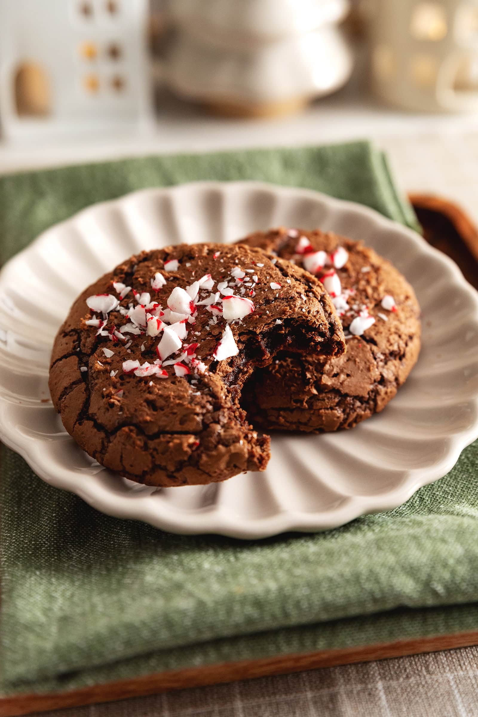 Two chocolate peppermint cookies with a bite taken out of one of them.