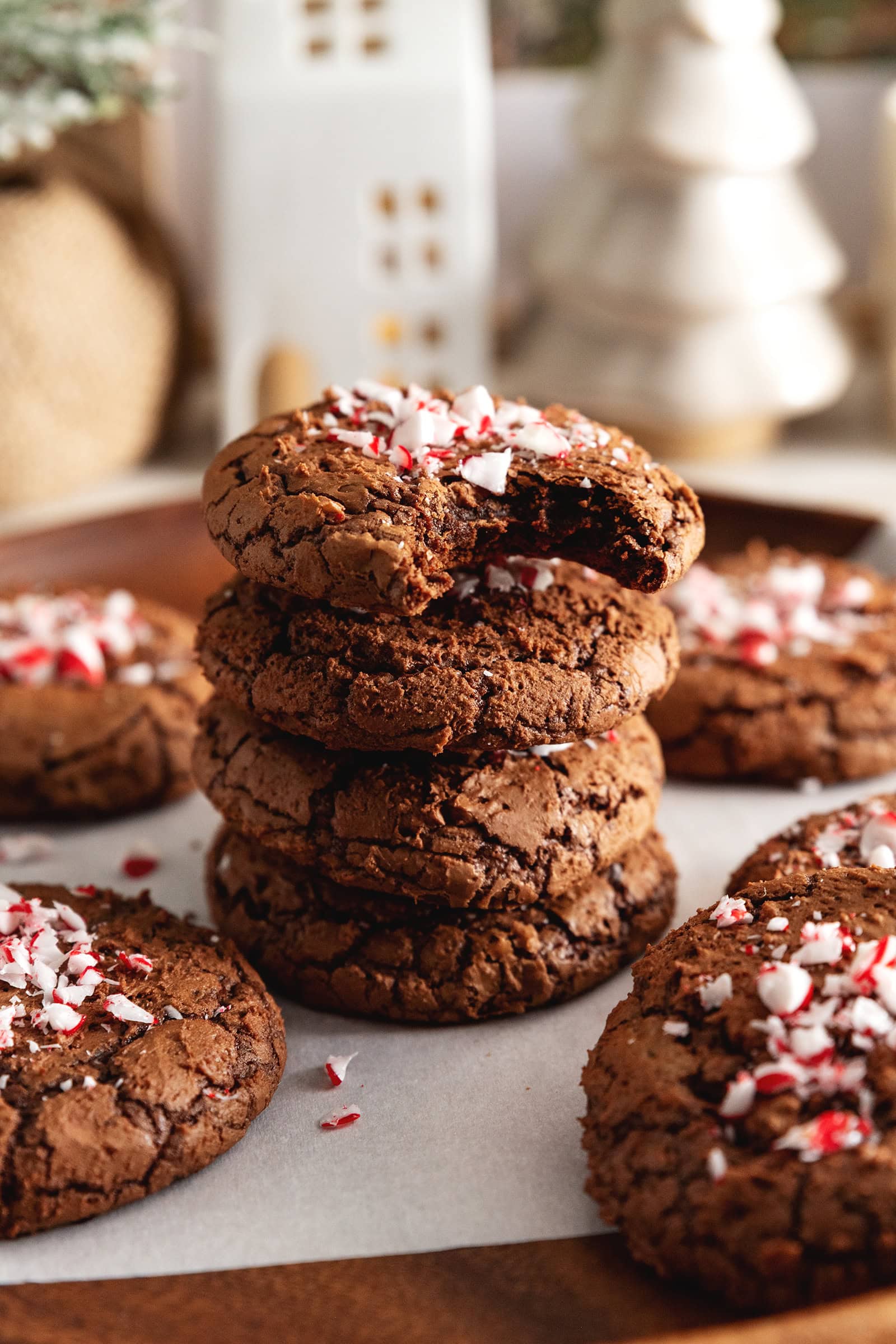 A stack of four chocolate peppermint cookies with a bite taken out of the one on top.