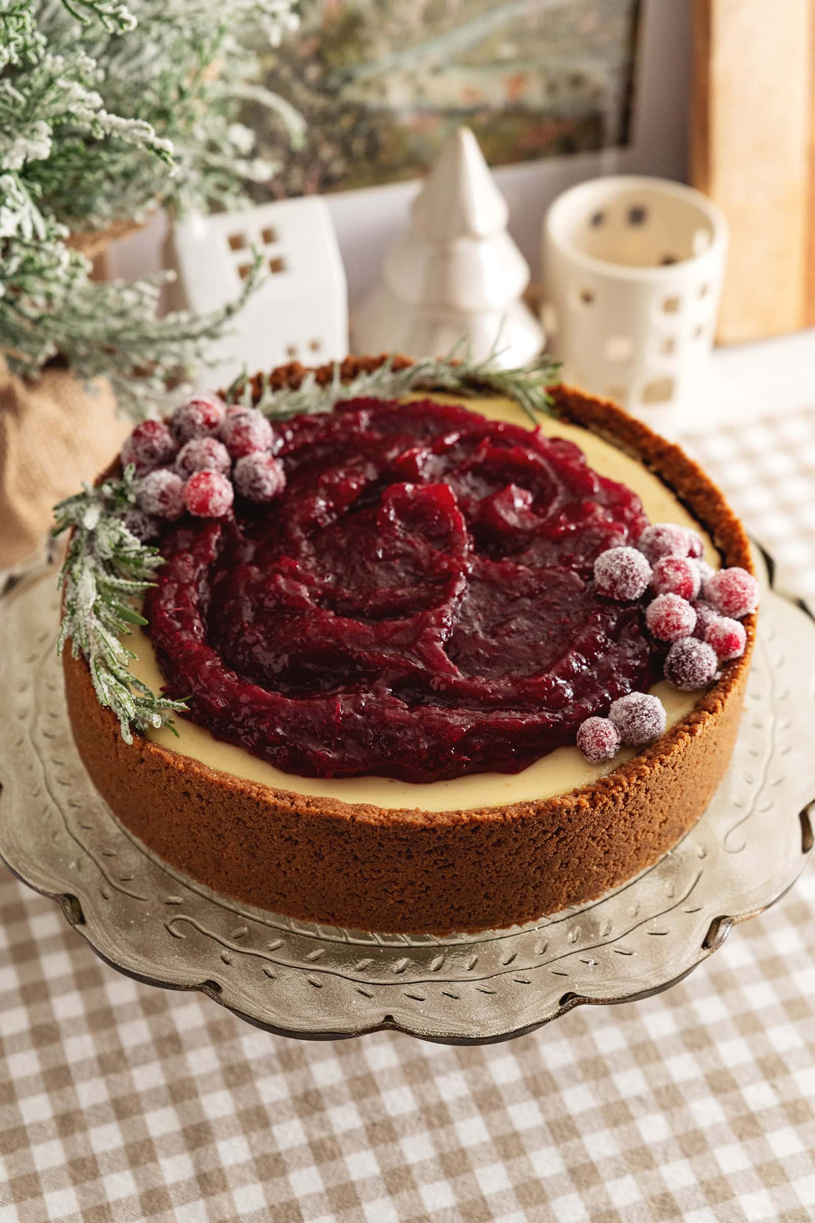 A cranberry orange cheesecake on a cake stand.