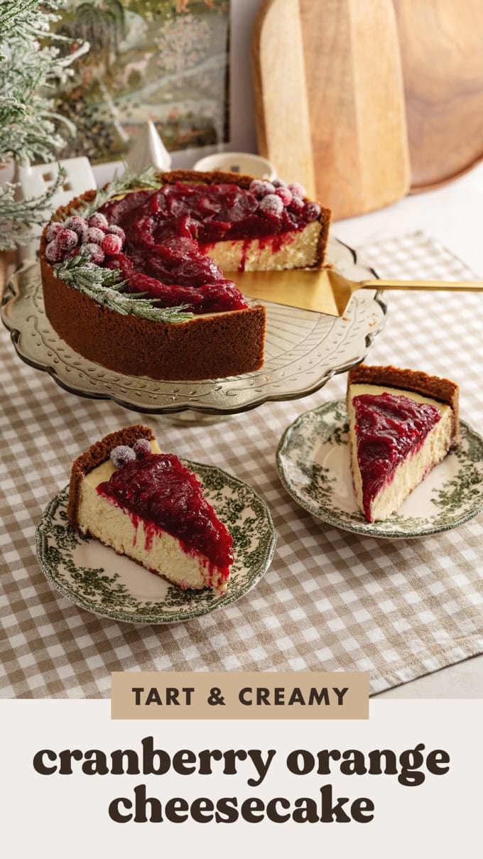 Two slices of cranberry orange cheesecake on plates in front of the rest of the cake on a cake stand.