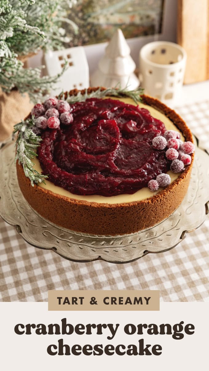 A cranberry orange cheesecake on a cake stand.