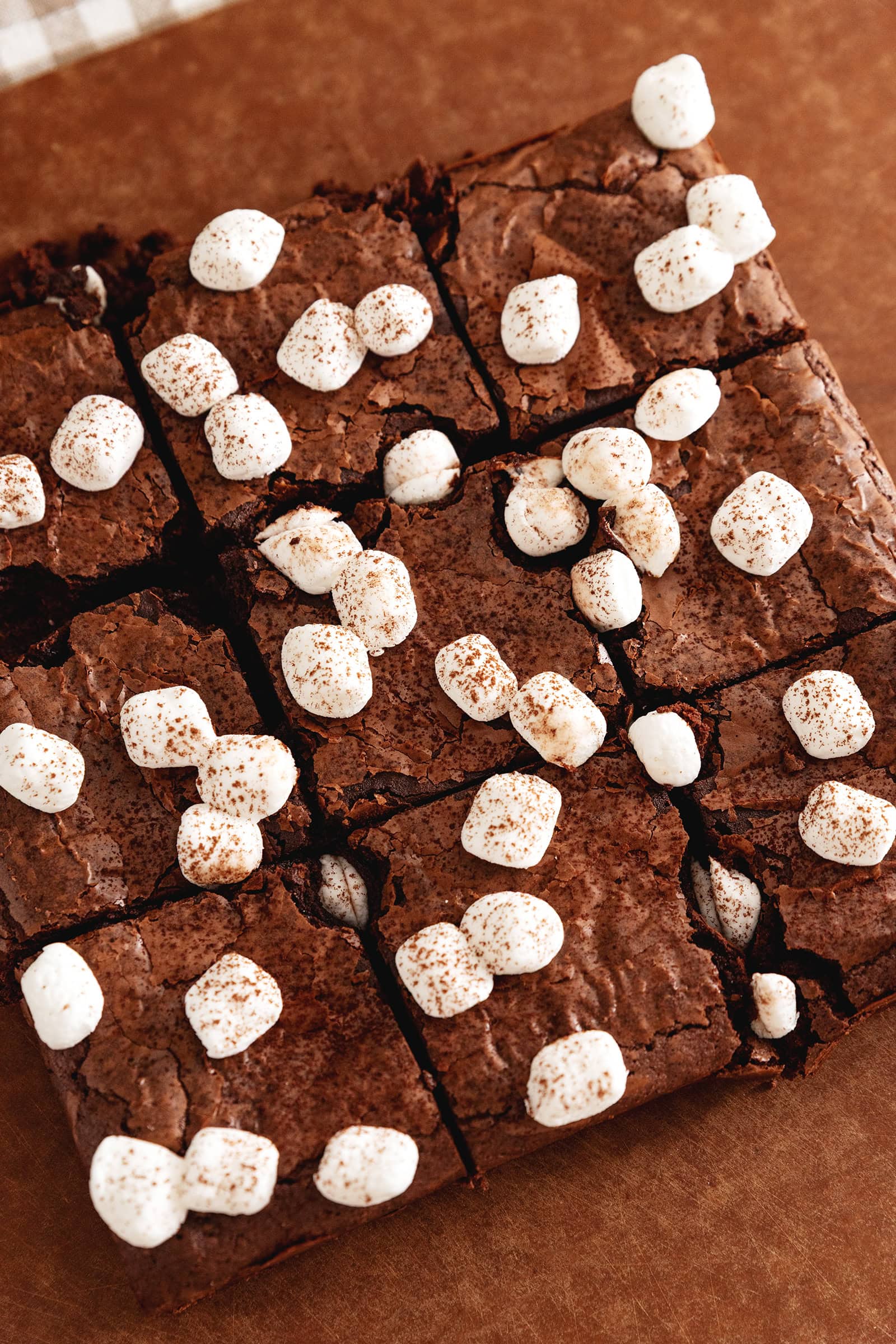 Hot chocolate brownies cut into squares with marshmallows on top.