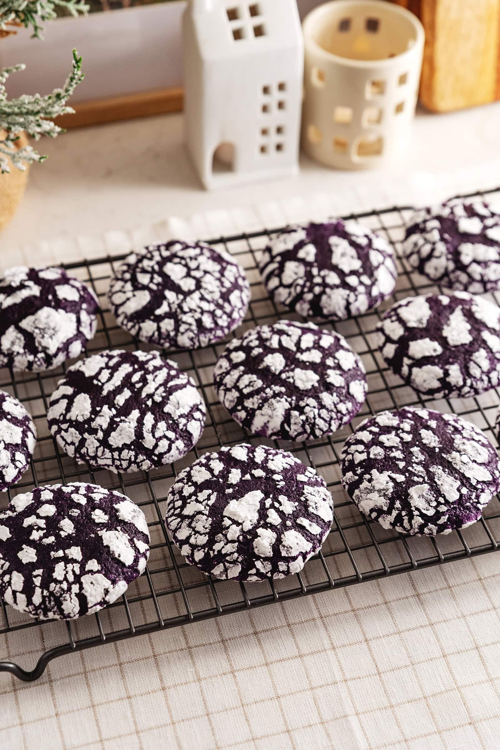Ube crinkle cookies lined up on a wire rack.
