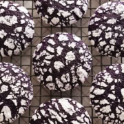 Top down view of ube crinkle cookies lined up on a wire rack.